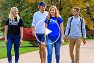 President Lori Sundberg walking with students on campus