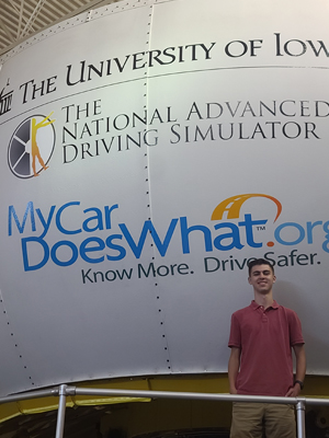  Tommy in front of the University of Iowa Driving Safety Research Institute simulator.